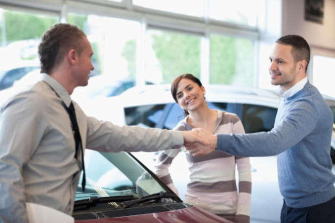 Couple shaking hands with car dealer: MaxAutoPro Auto Advice Blog