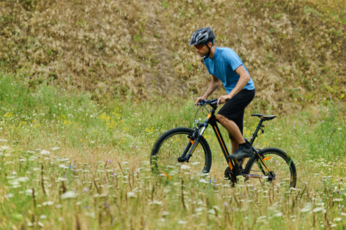 mountain biker in field: MaxAutoPro Travel Blog