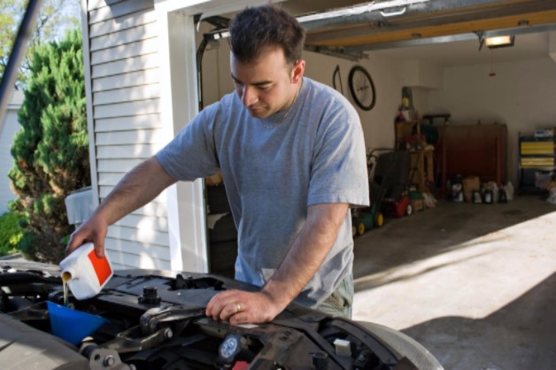 man taking care of car and changing oil