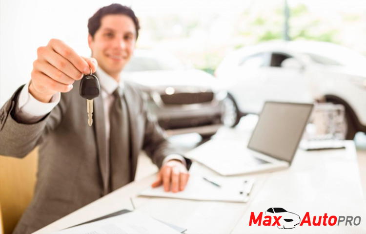 used car salesman handing car keys to buyer